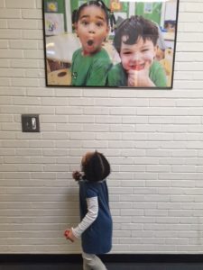 Chloe admiring her portrait in the Frazer hallway