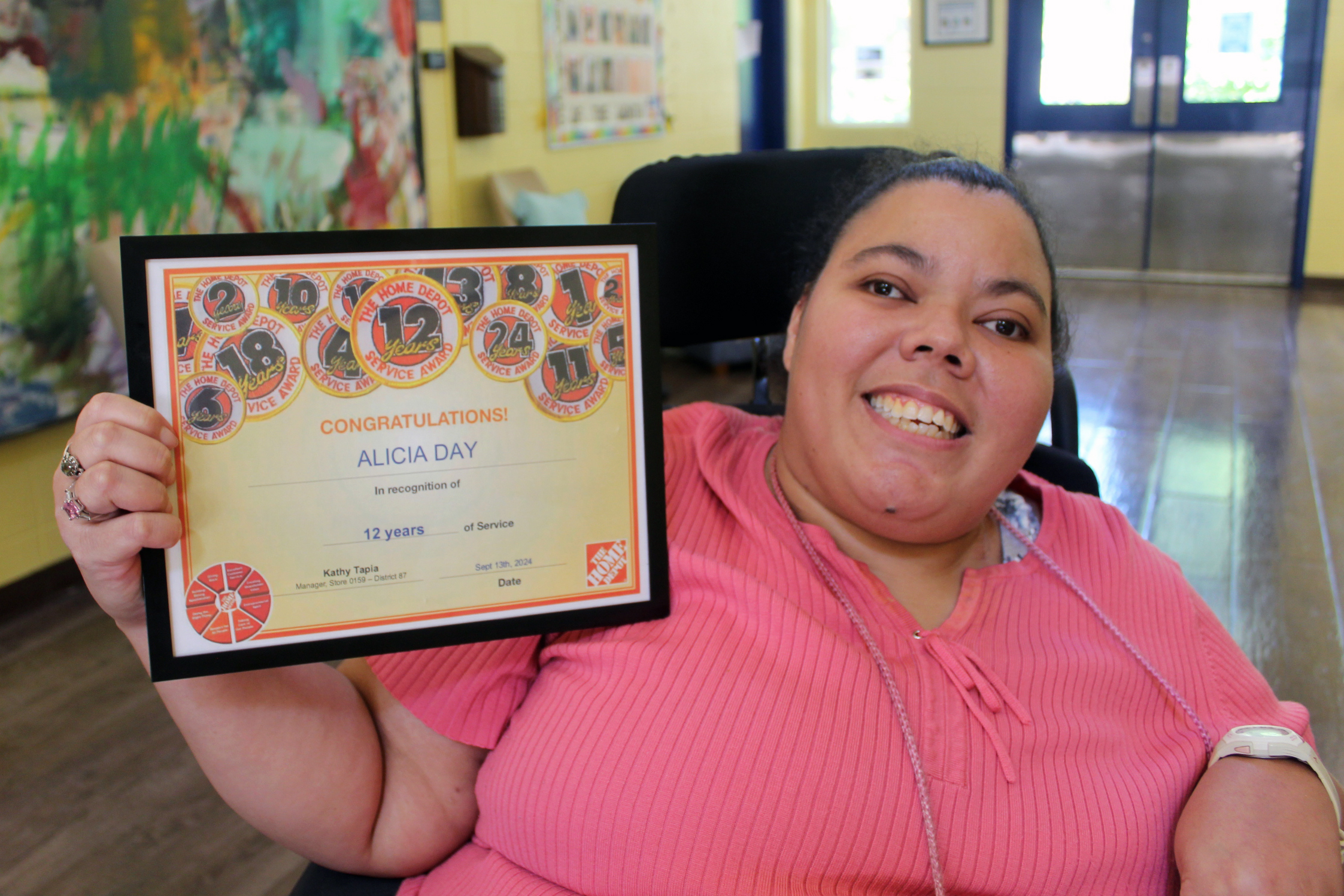 Alicia showing off her certificate for 12 years of service with Home Depot.