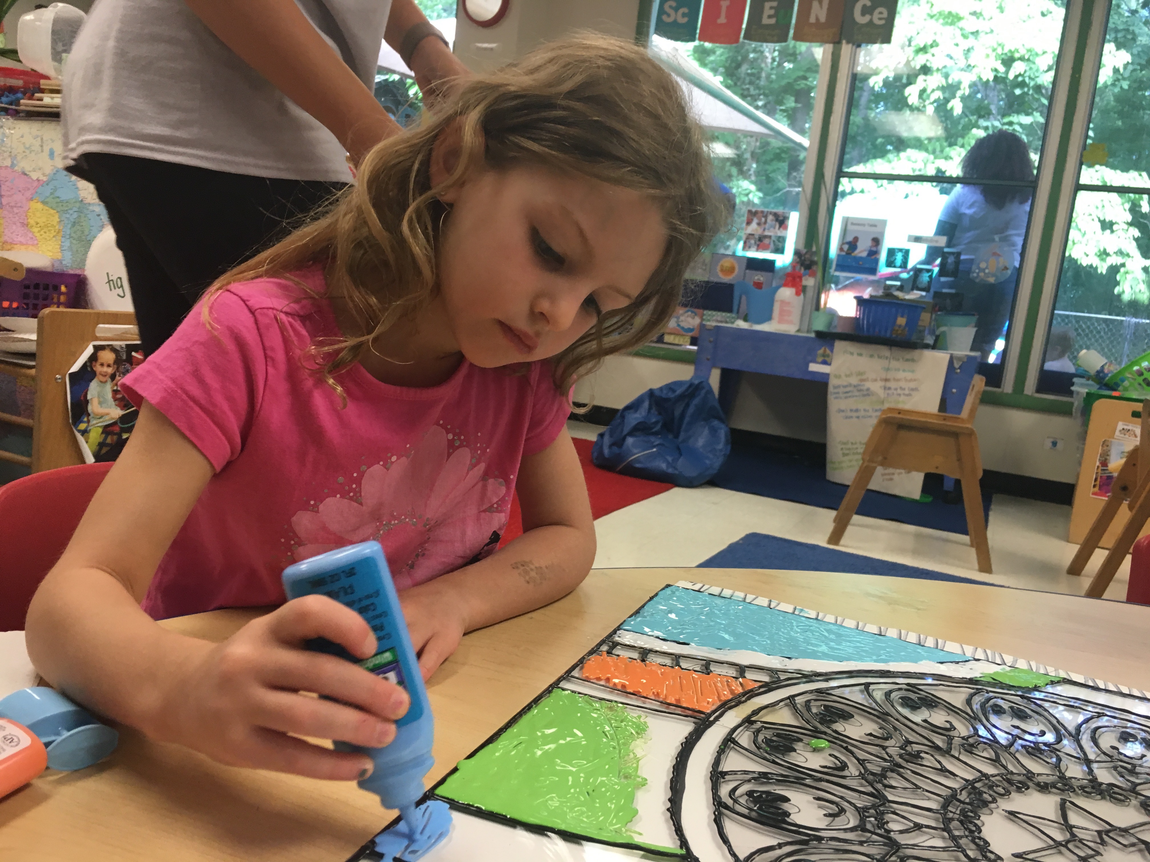 Pre-K student helping with the new art