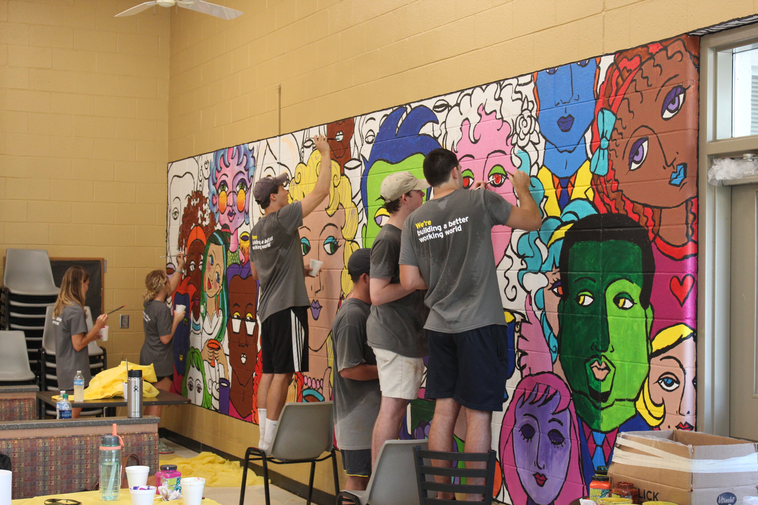 Ernst & Young interns working on the mural in one of our Adult Program rooms